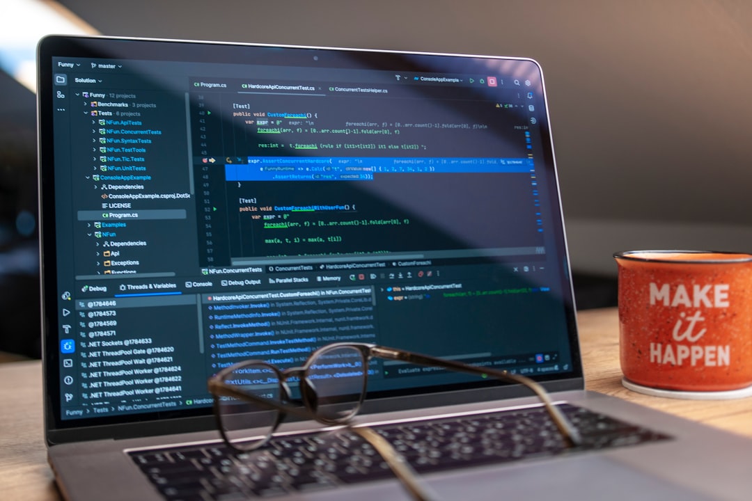 Laptop screen displaying code with glasses and mug.